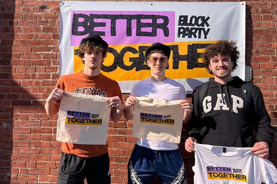 MCLA "Better Together" block party three friends holding merchandise