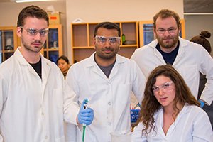 four pre-med students in lab coats