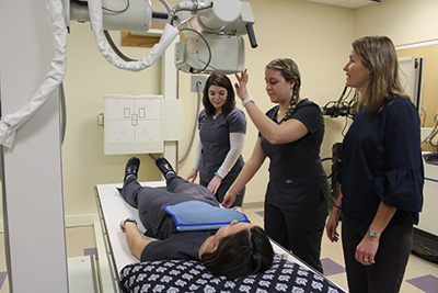 Students being instructed on equipment by professor