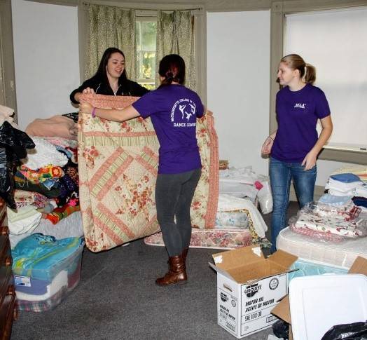 Students fold a quilt