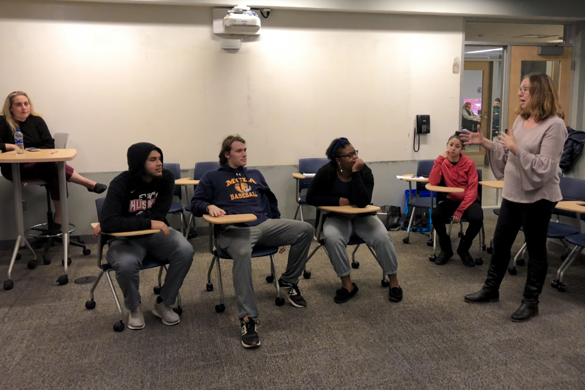 Five students sitting in a classroom as they are instructed by a member of Barrington Stage Company.