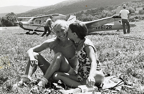 girl kissing boy in front of planes