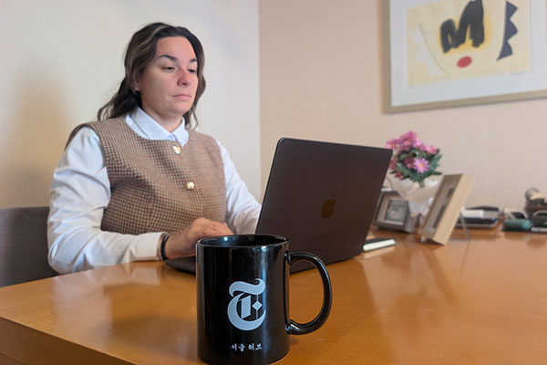Jen Thomas sitting at their desk