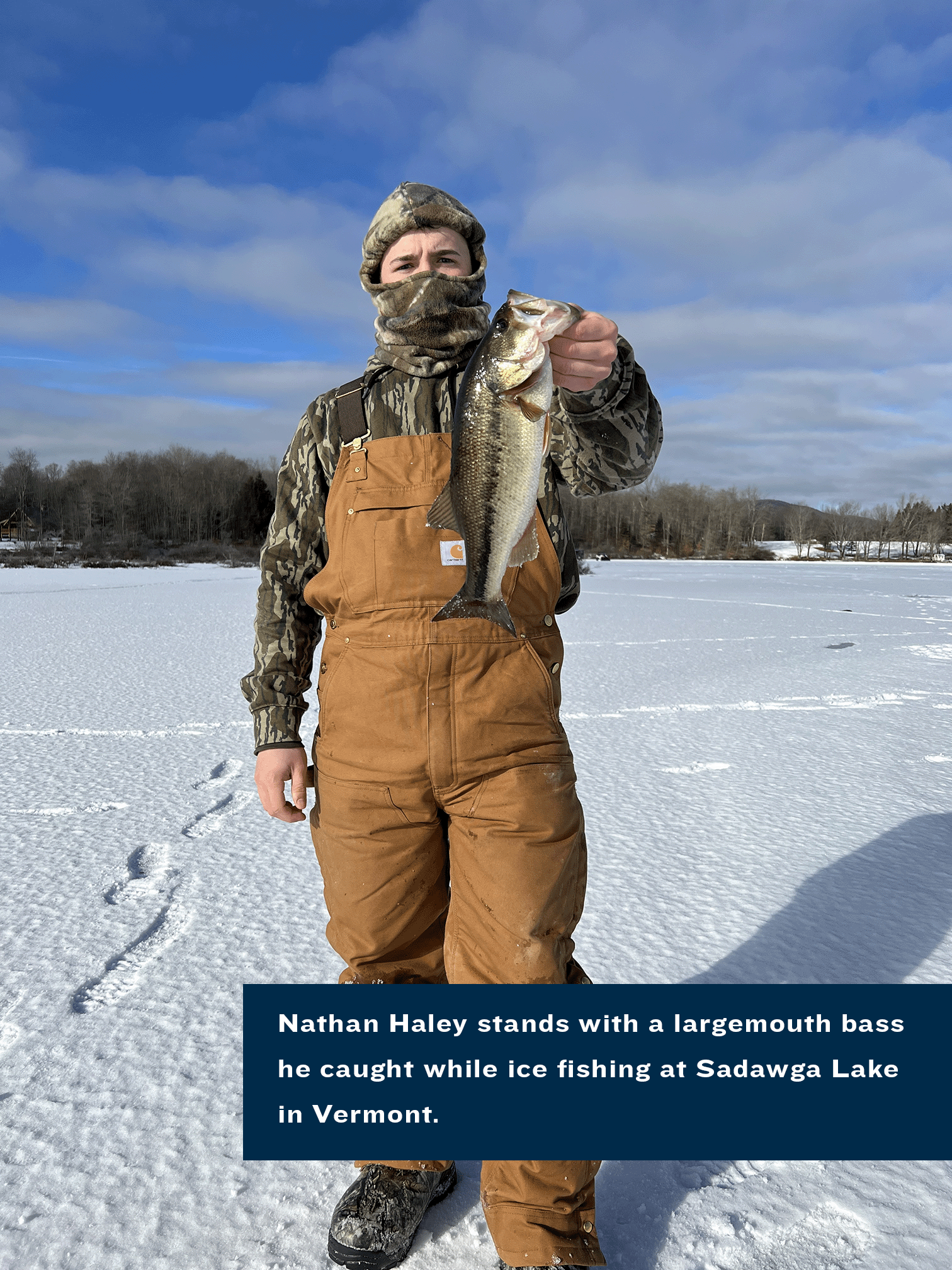 Nathan Haley stands with a largemouth bass he caught while ice fishing at Sadawga Lake in Vermont. 