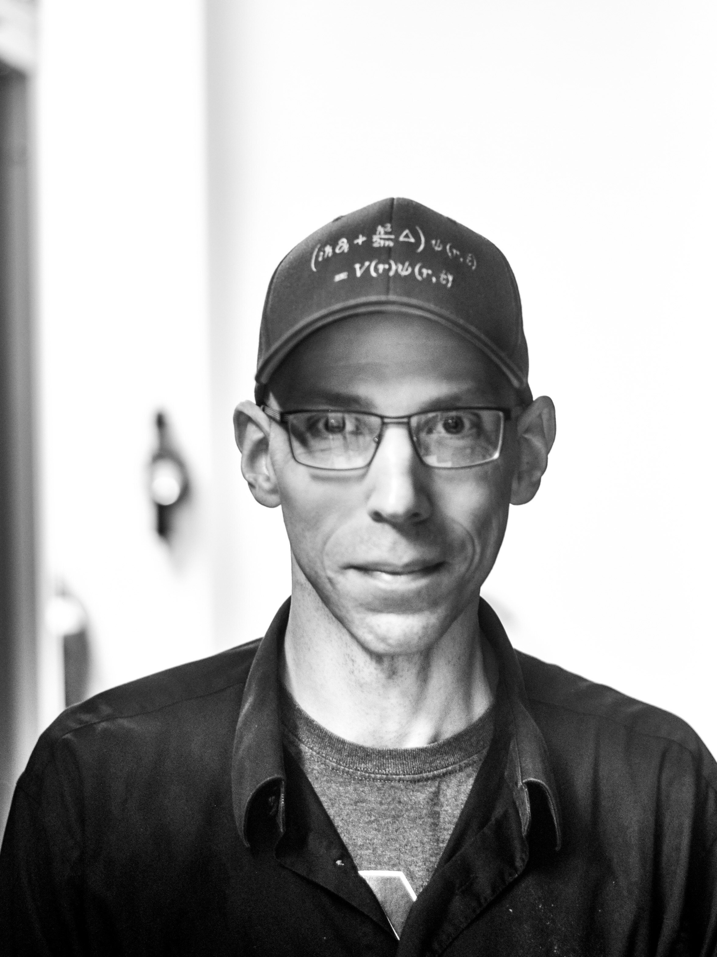 David Hoxie headshot in black and white. Sporting a baseball cap.