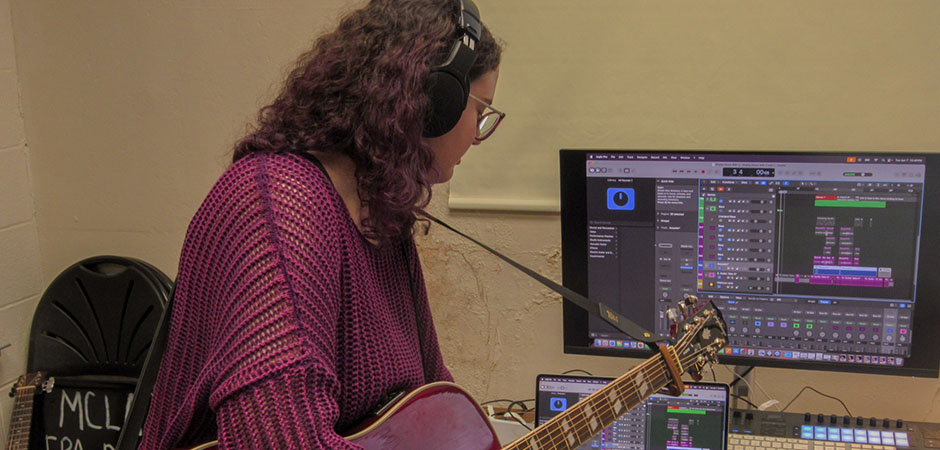 MCLA Helen Kahn holding a guitar in the studio