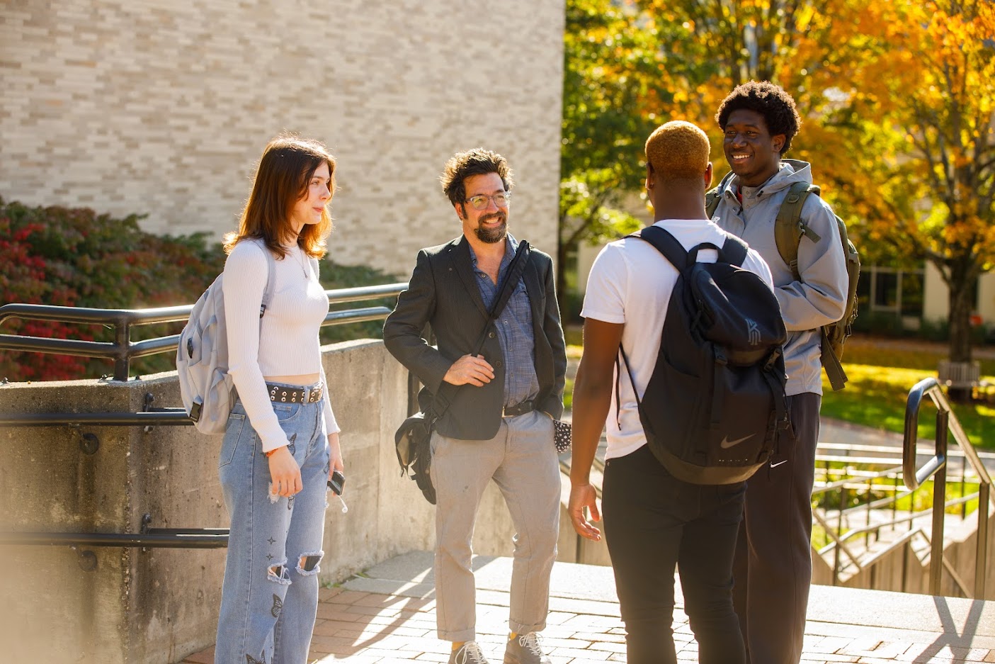 Professor speaks with a group of students outside of class.