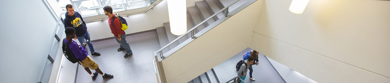 students talking on bowman hall staircase