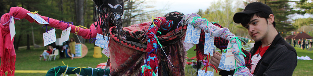 Student hanging his artwork at an outdoor exhibition