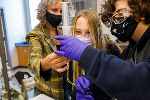 Professor assisting student in science project