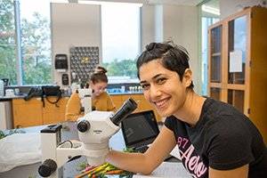 student looking up from her microscope